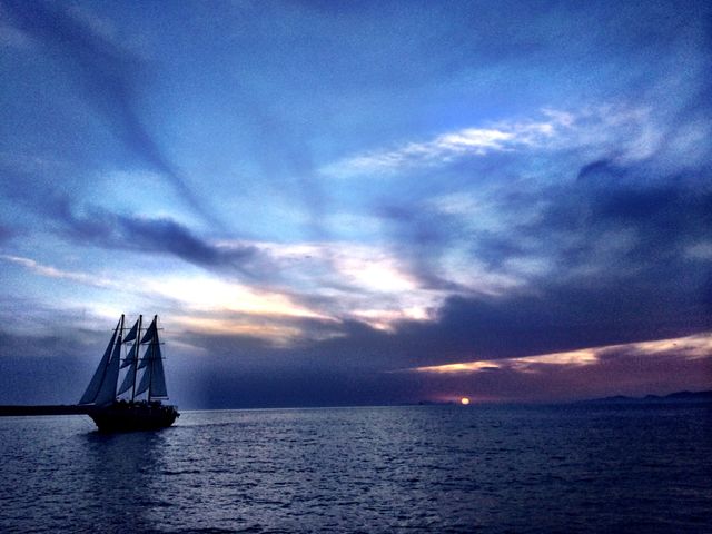 Away into the night . Sail boat sails away in Santorini 