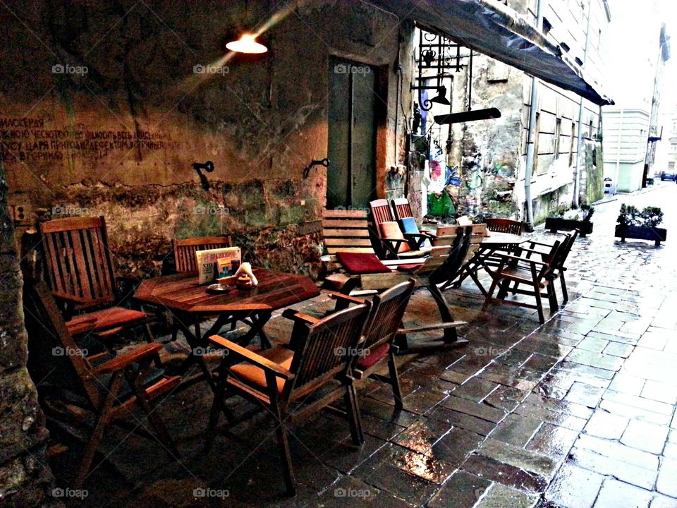 outdoor cafe without people on a rainy day, empty, wet tables and chairs