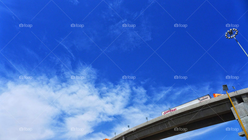 A semi truck seen crossing the road on an elevated ramp