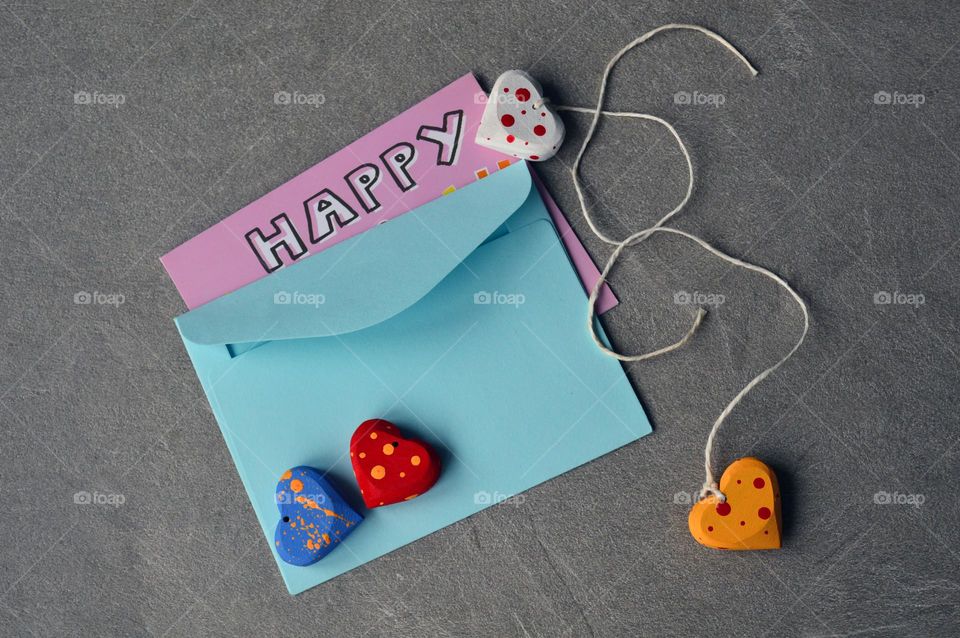 Multicolored wooden hearts near a greeting card