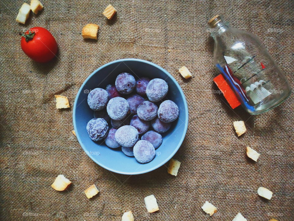 frozen plums, tomatoes white crackers on the table