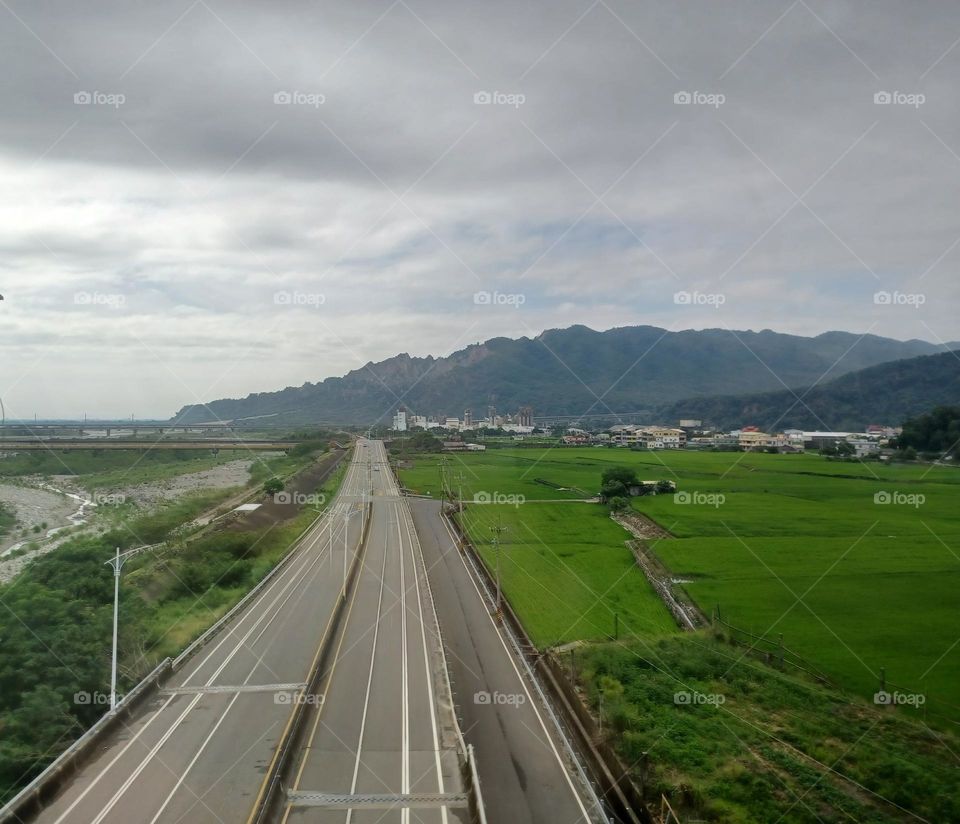Pastoral view with a road in the middle.