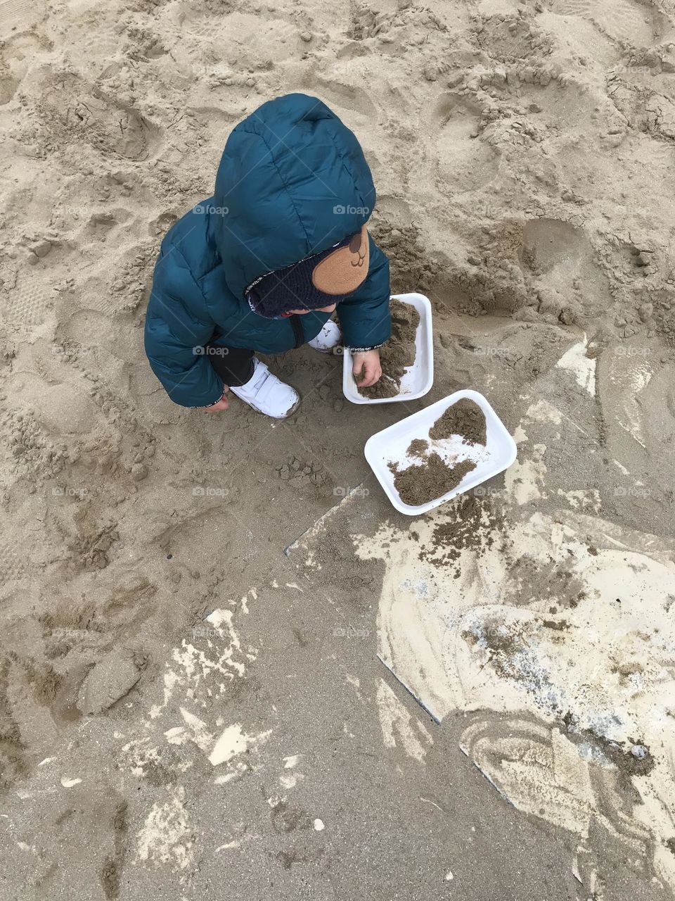 children play in the sand on the beach in winter