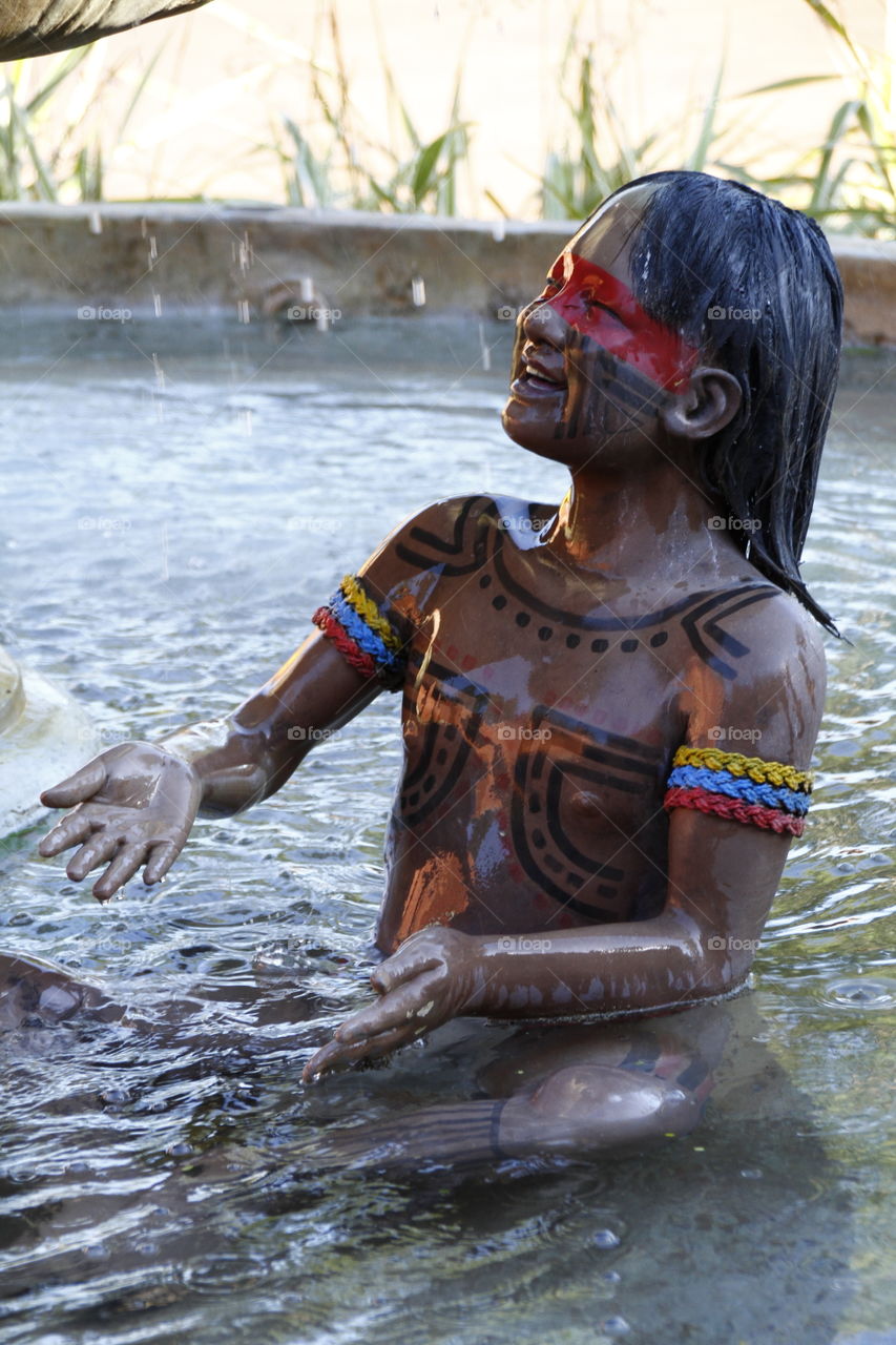 statue of an indigenous girl playing in the water