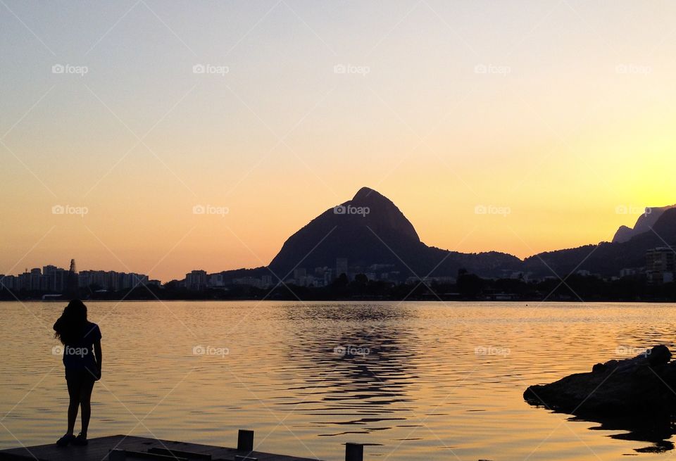 A girl watching the sunset by a lake,in Rio de Janeiro