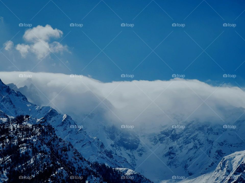 clouds walk through Snowy mountains