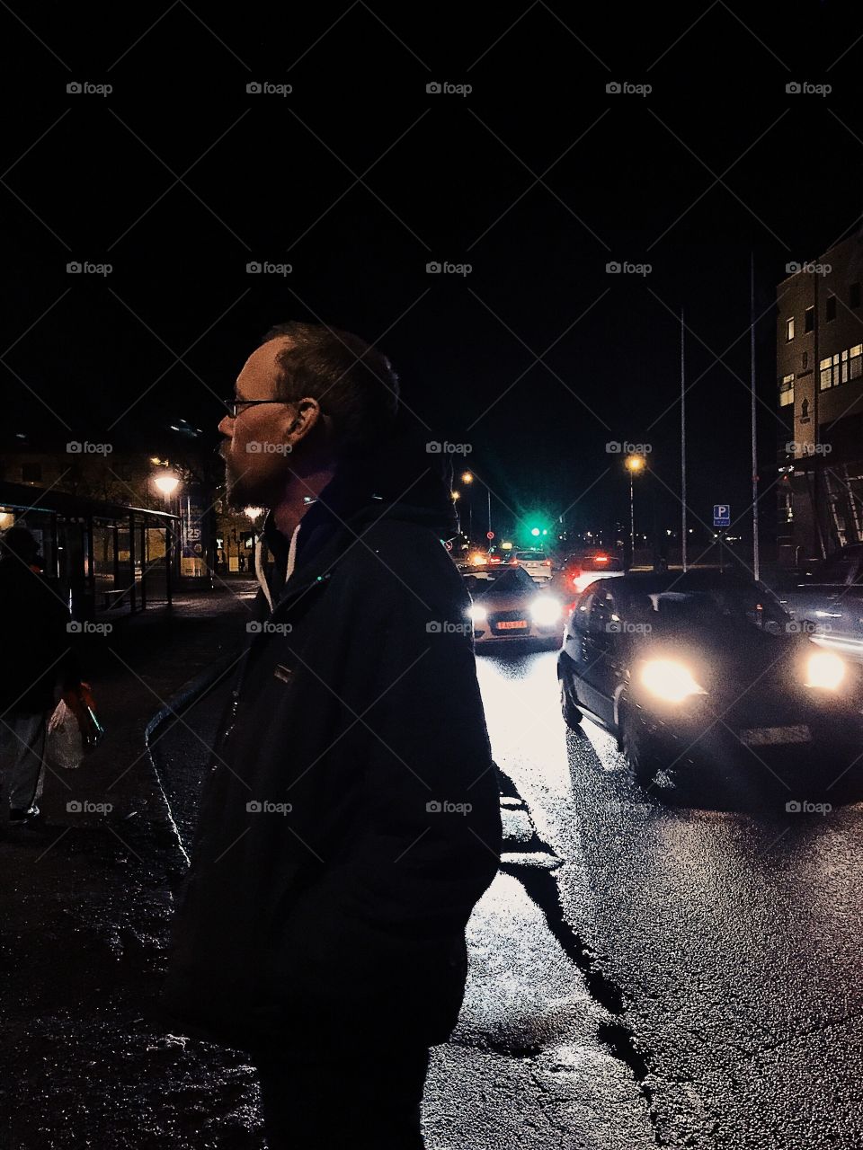 Man standing on road at night