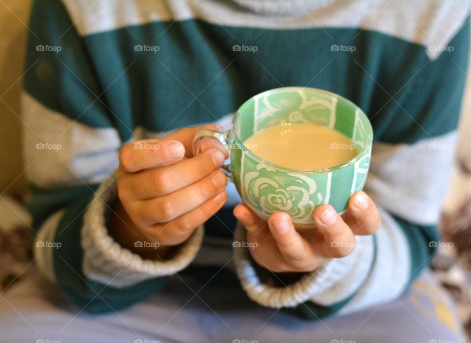 mint green cup of coffee with milk in the child hands