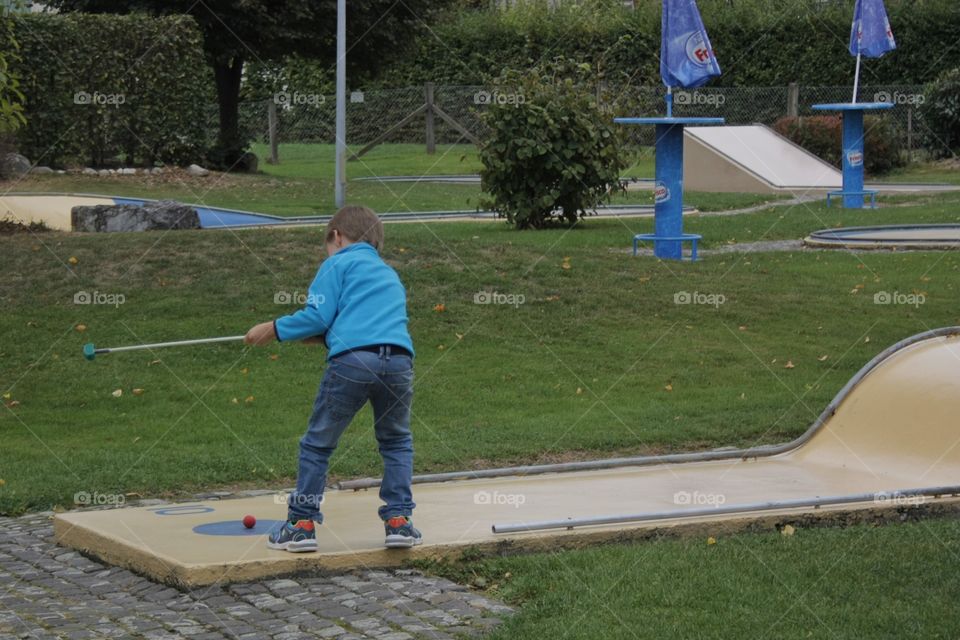 Mini Golf. Little young boy playing mini golf in Sempach Luzern