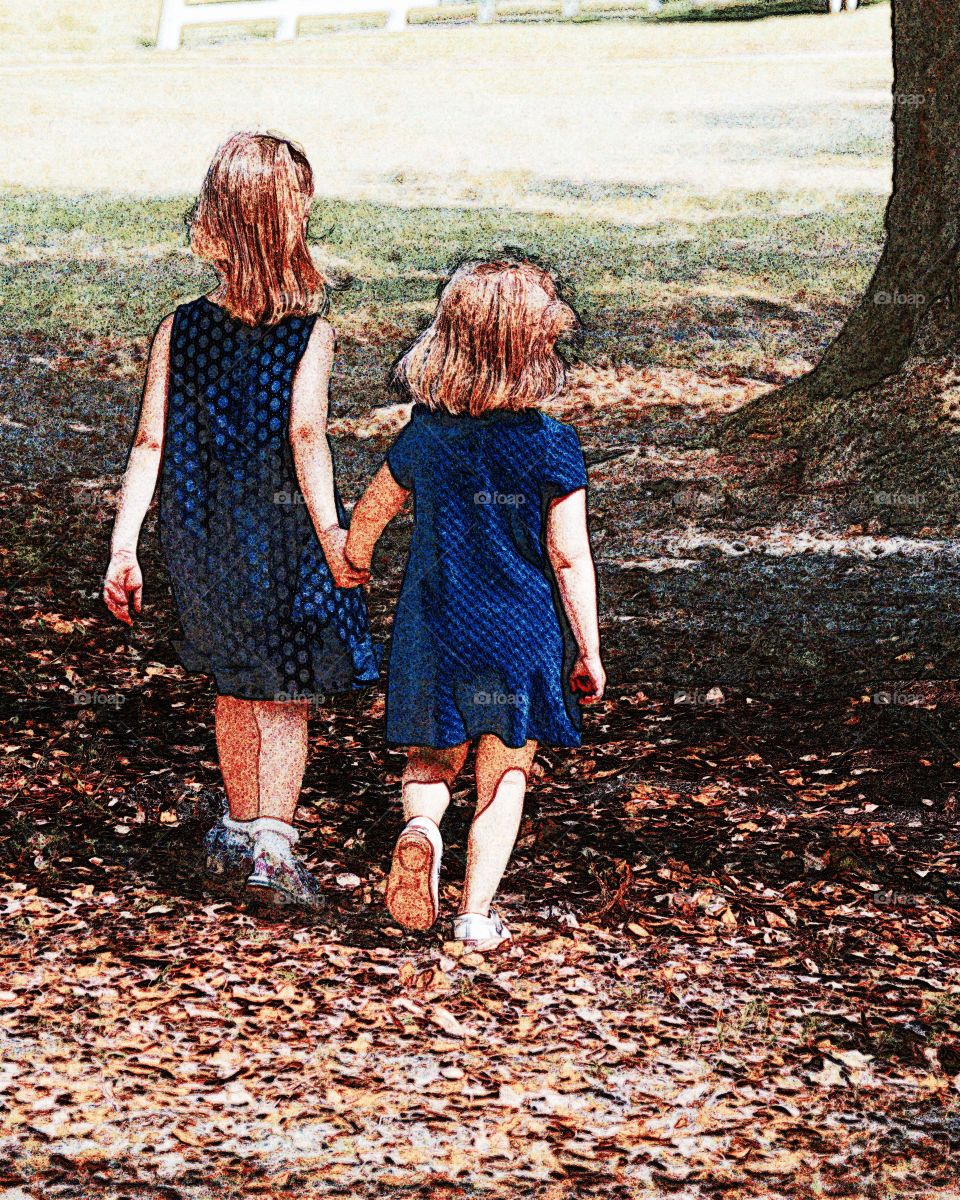 Sisters in the Park. Walking hand and hand little girls 