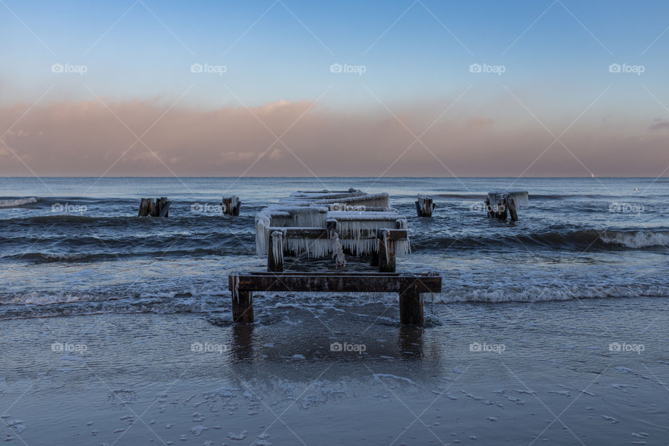 Frozen and broken pier over sea