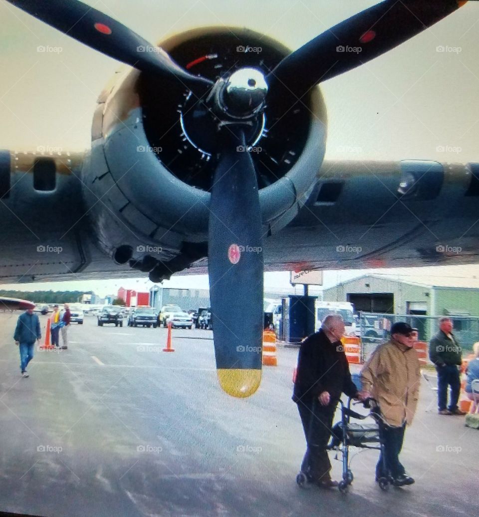WWII vintage Bomber wing with enormous propellers. The two older men are U.S. Veterans🇺🇸, one uses a Walker & the other needs to use an Oxygen tank to breathe.