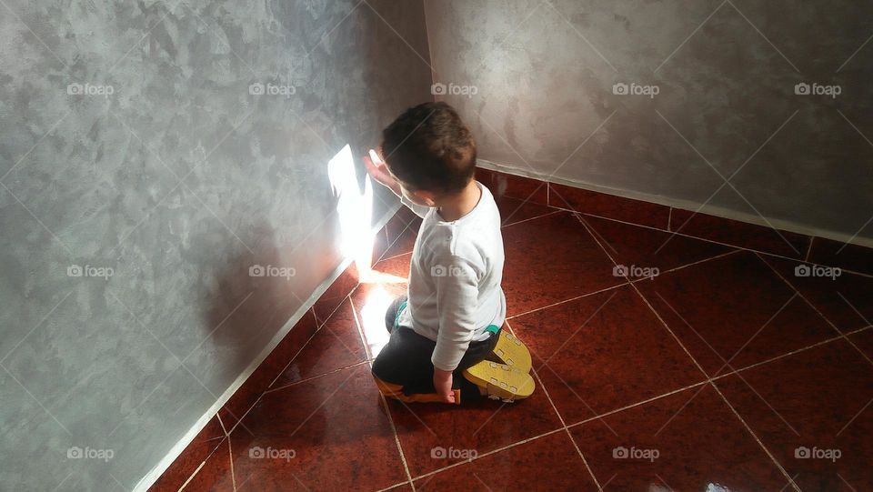 A little boy is trying to discover his shadow.