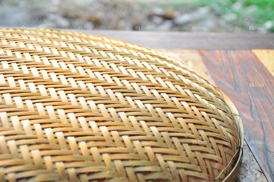 Brown woven bamboo closeup texture. Wicker texture. Winnowing or threshing basket on the table. Woven bamboo pattern. Diagonal pattern texture. Abstract texture