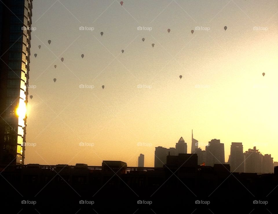 Hot Air Balloons over Dubai skyline at sunset.
