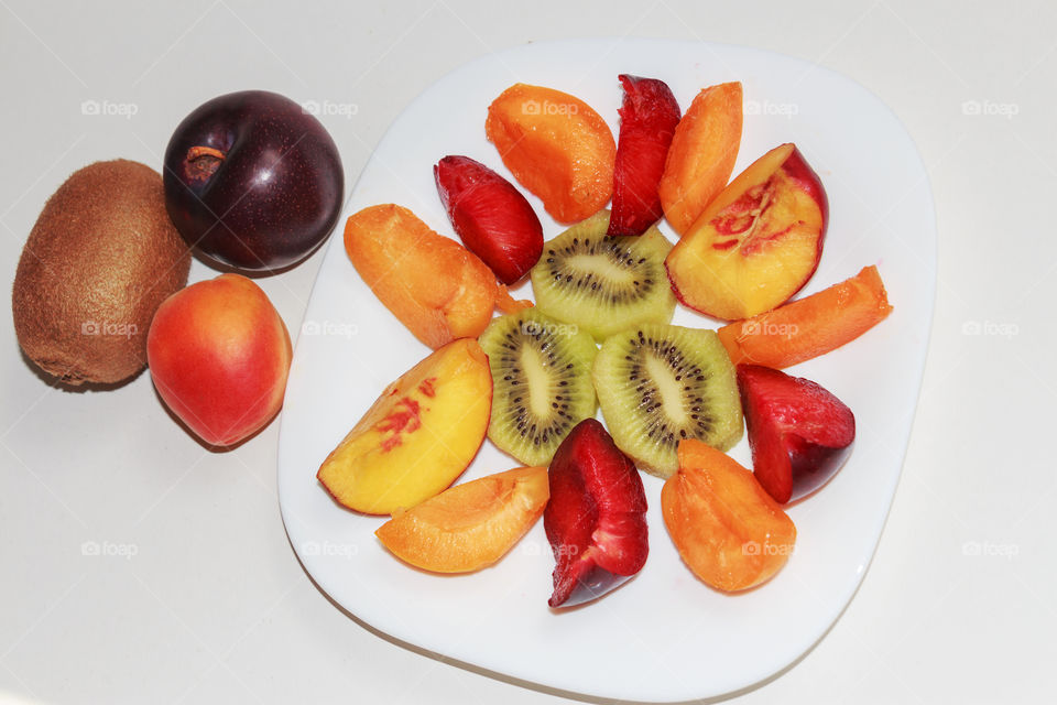 Fruits and fruit salad of apricot, blue plum, kiwi and peach