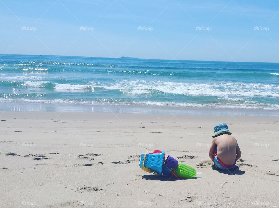 Boy plays on beach in California.