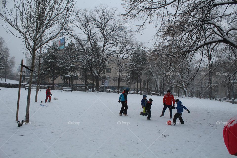 Children playing a fudball at the snow