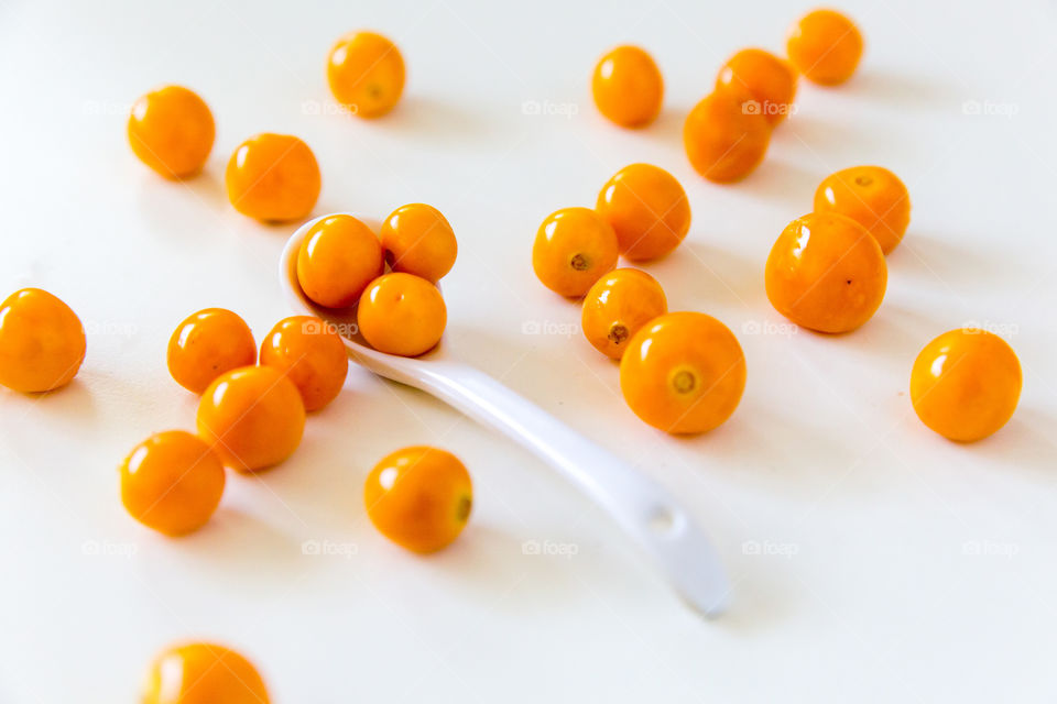 Product gooseberries on a pure white background with white spoon