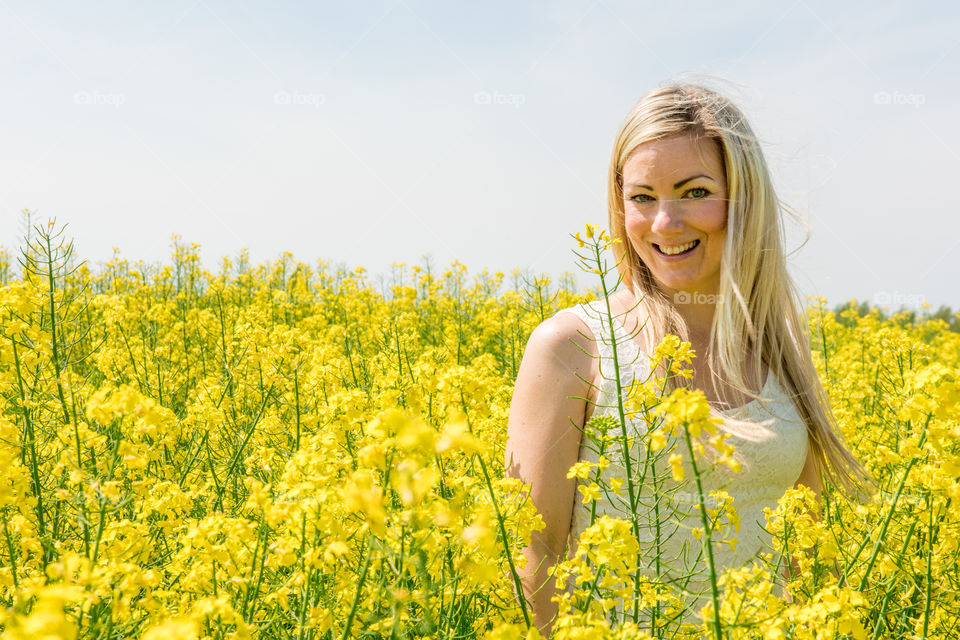 Woman 30 years old walking in a Raps field outside Malmö in Sweden.