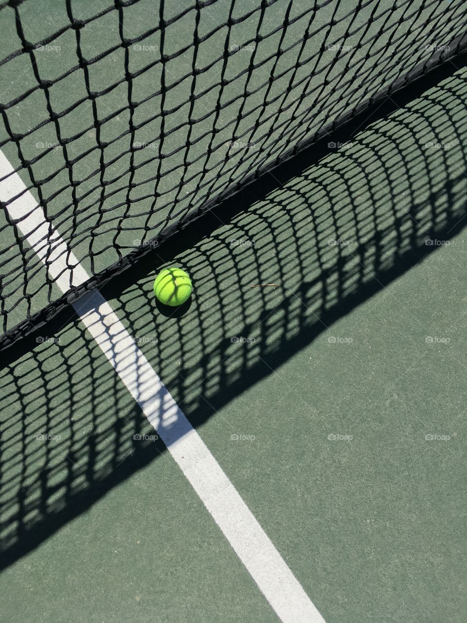 Tennis ball against the shadow of the net 