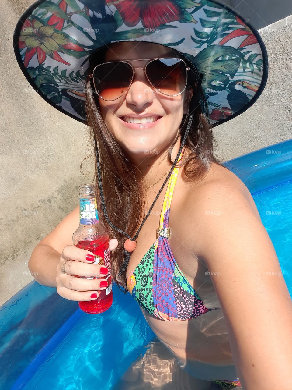 smiling woman with cool hat in the pool