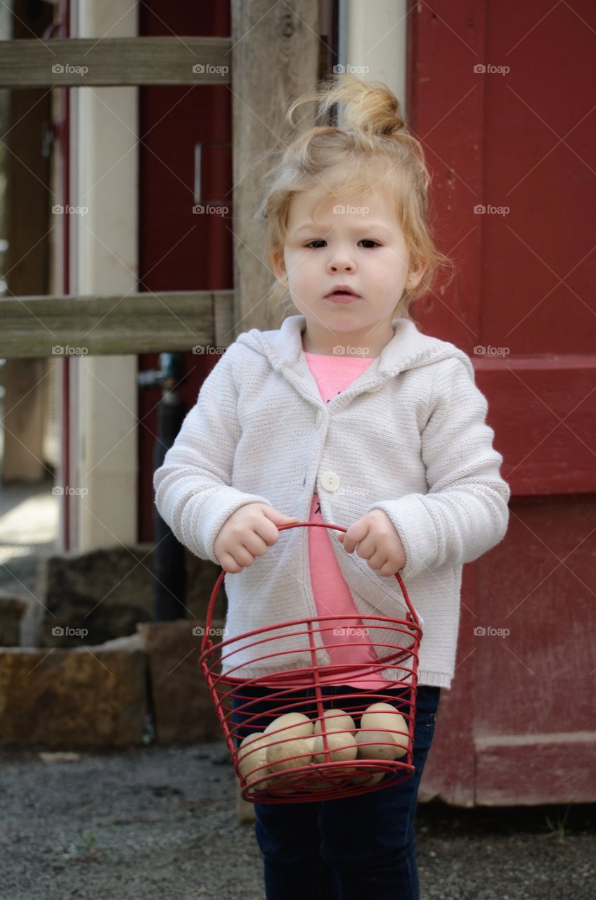 Cute girl holding eggs in basket