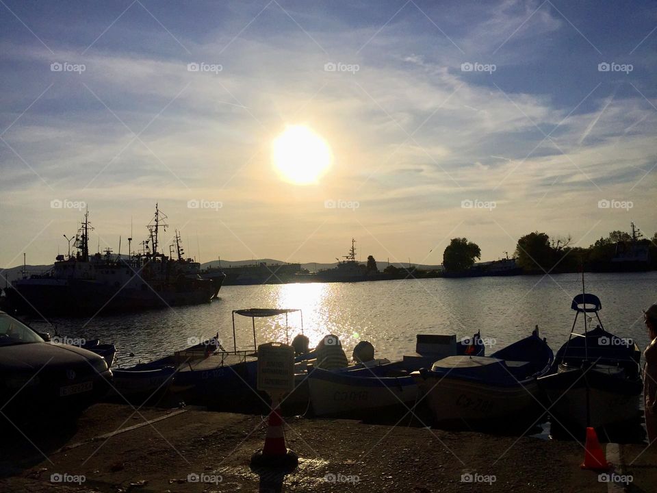 Под светом луны ночное небо преображается в глубокий синий оттенок. Рыбацкие лодки покачиваются у причала в ожидании нового дня 