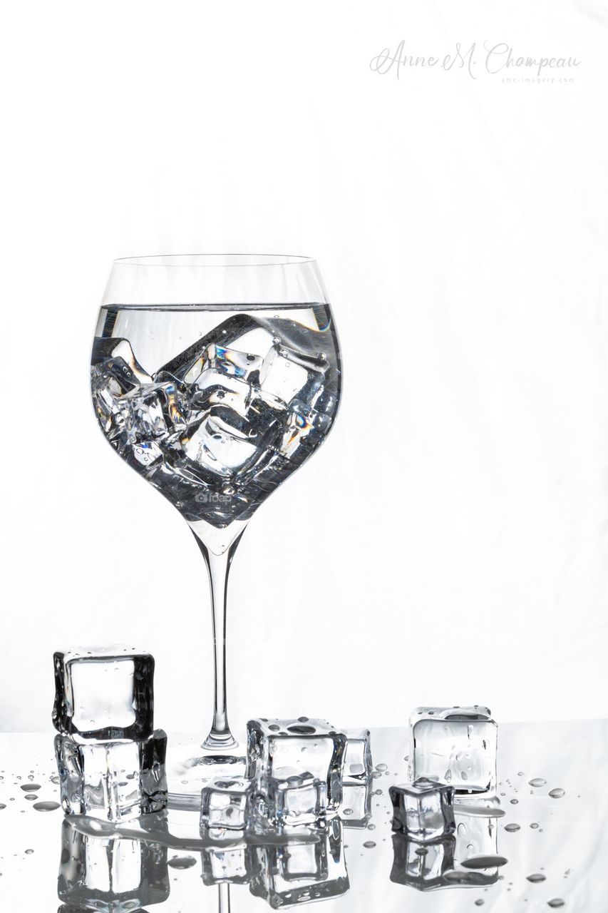 Ice melting in a wine glass on white background 