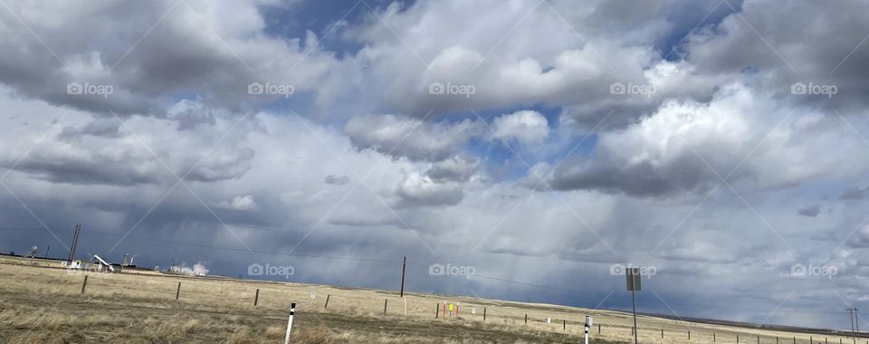 White fluffy clouds followed by rainy dark clouds over the prairies in Alberta,Canada