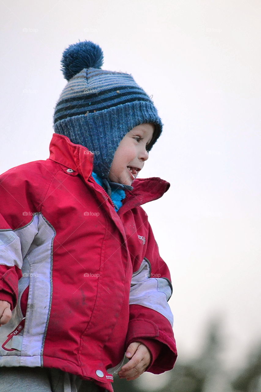 Cute and happy toddler in winter outdoor clothing