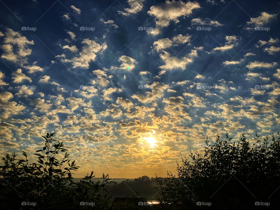 A great sunrise to motivates us in a great new day. The clouds in the sky creating shadows and rays add to the beauty...