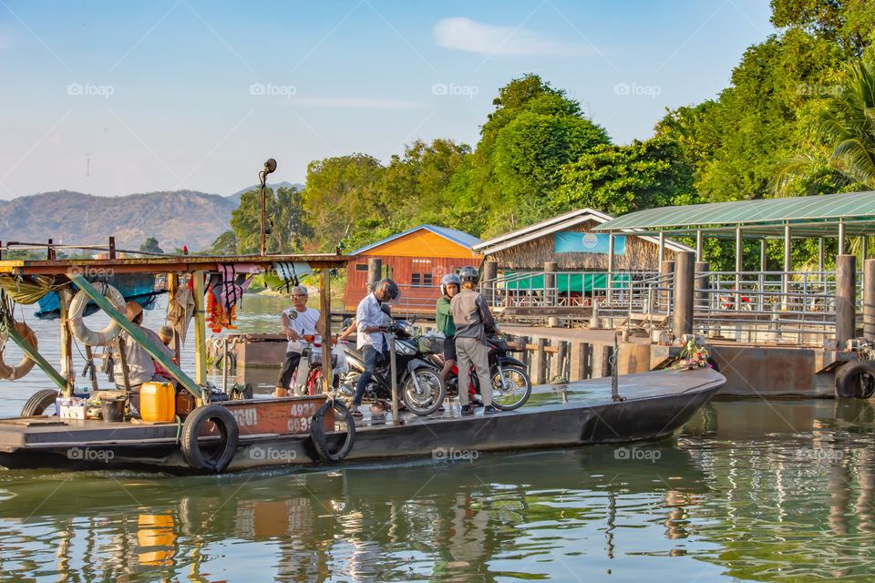 Ship passenger and motorbikes across  Khwae Noi river at Kanchanaburi Thailand.