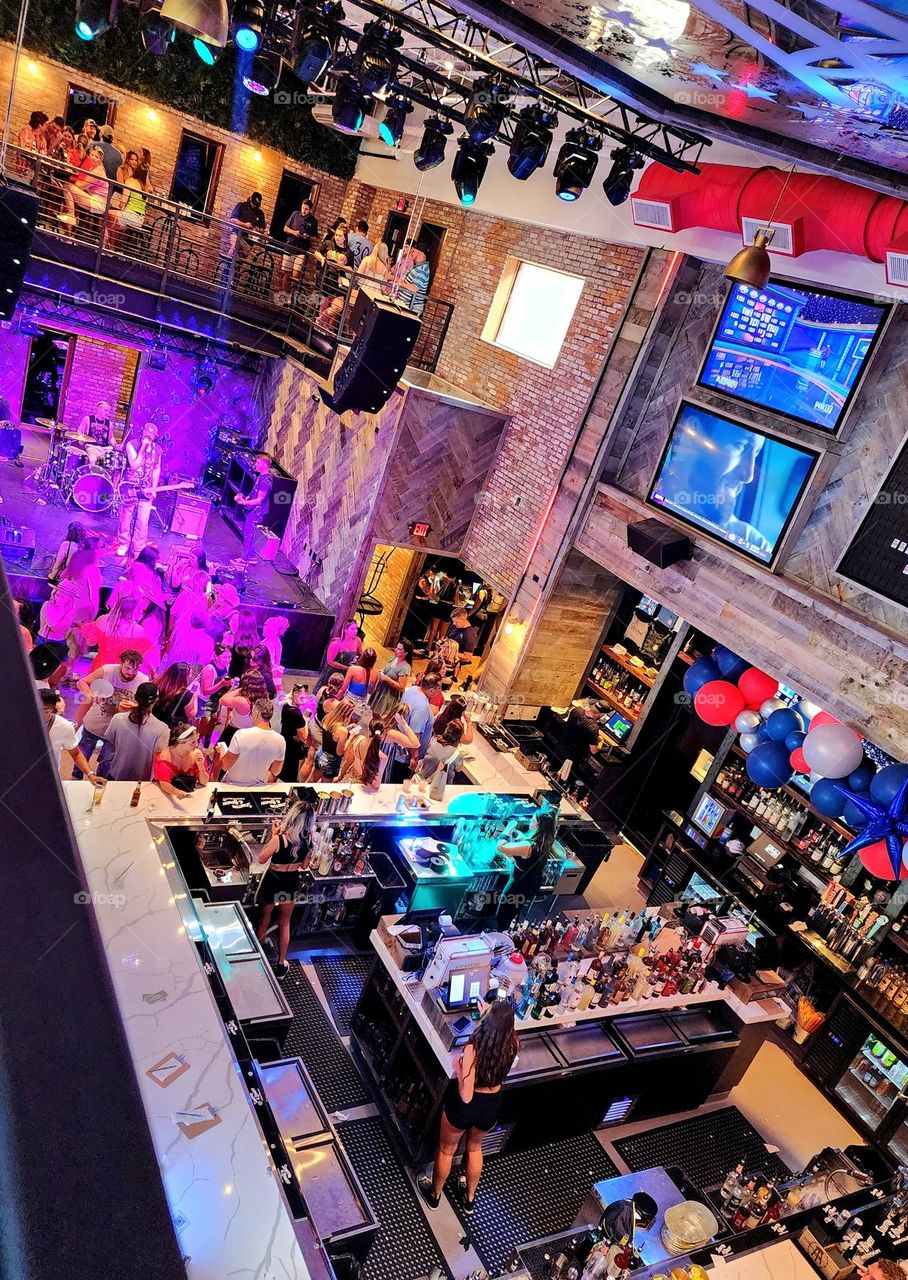 As a band plays on people crowd the scene celebrating a summer afternoon spent in leisurely fashion