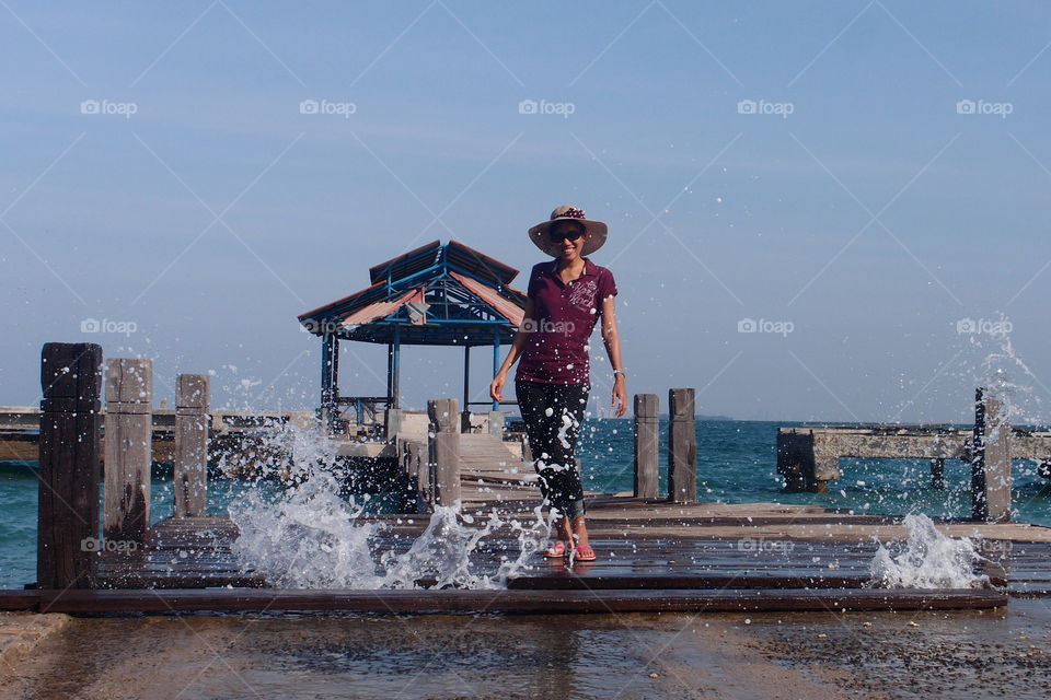 Splash. at the old jetty of an island in Jakarta with the sea water splashing under the bridge