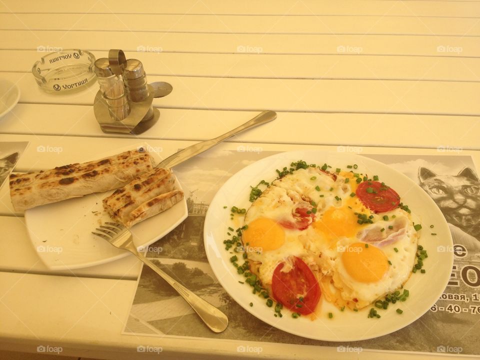 Morning eggs and pita on white wooden  table