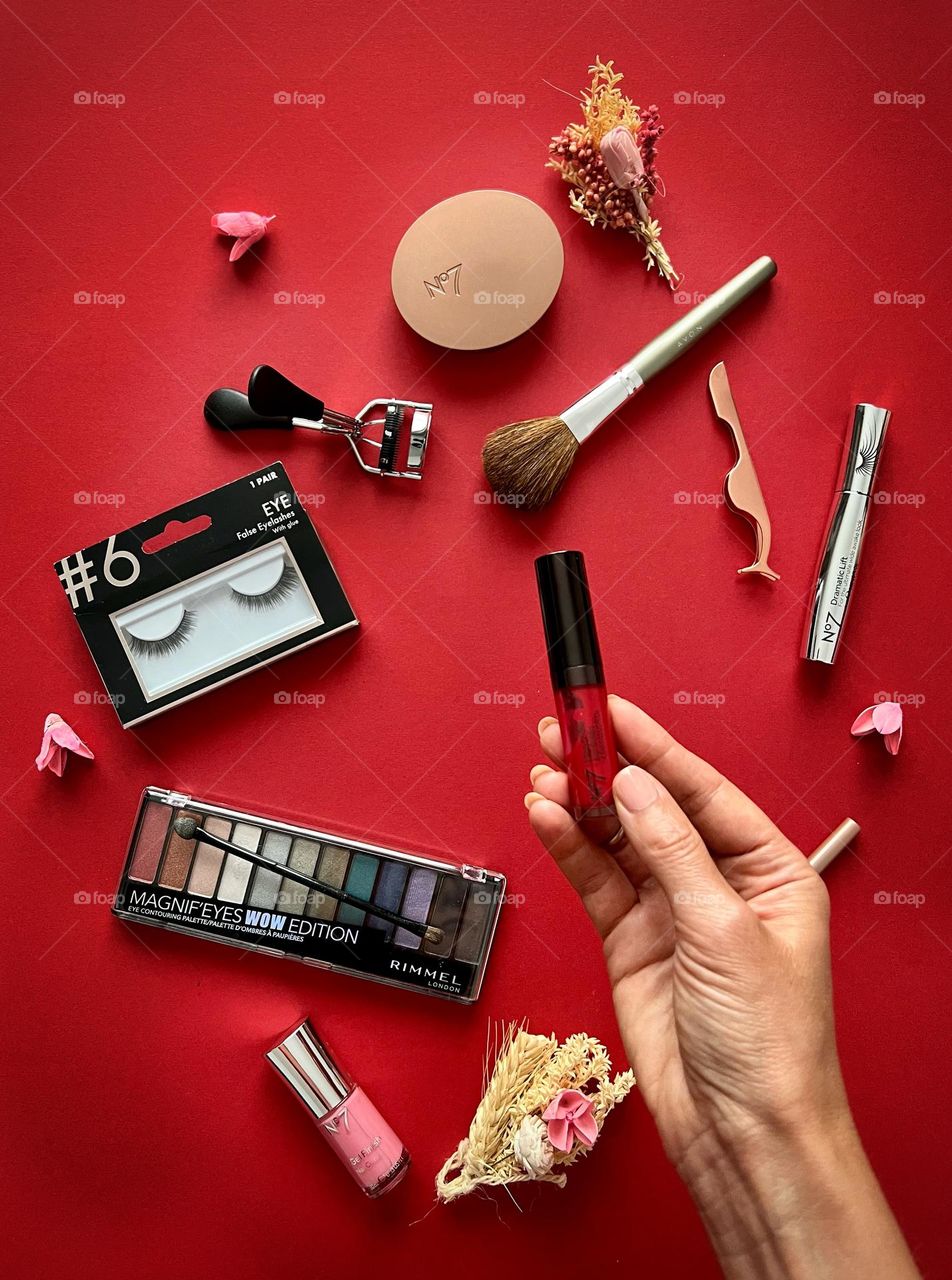 Decorating cosmetic, hand holding the red lipgloss, beauty brands.