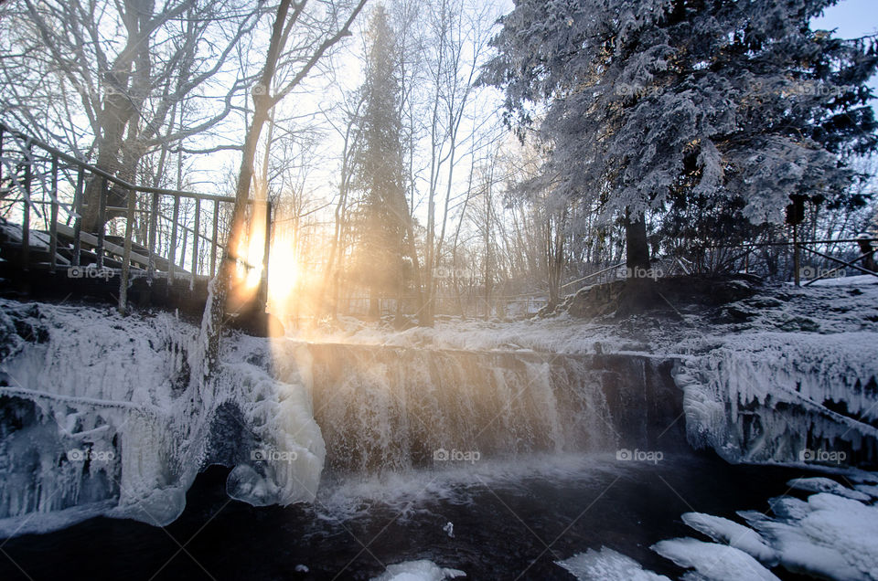 winter landscape, waterfall  in winter in the sunrise sunlight