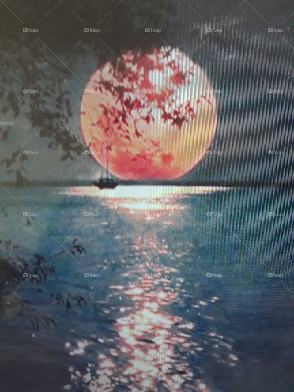 A beautiful full moon with a reddish tone with blue waters and fishermen in the background.