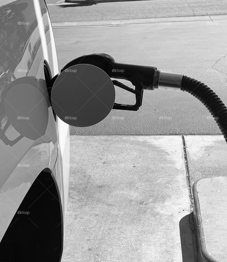 Putting gasoline in the car for a road trip at the gas station 