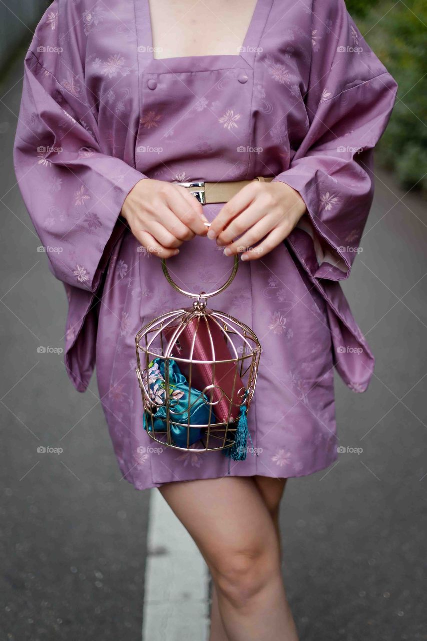 hands holding cage handbag