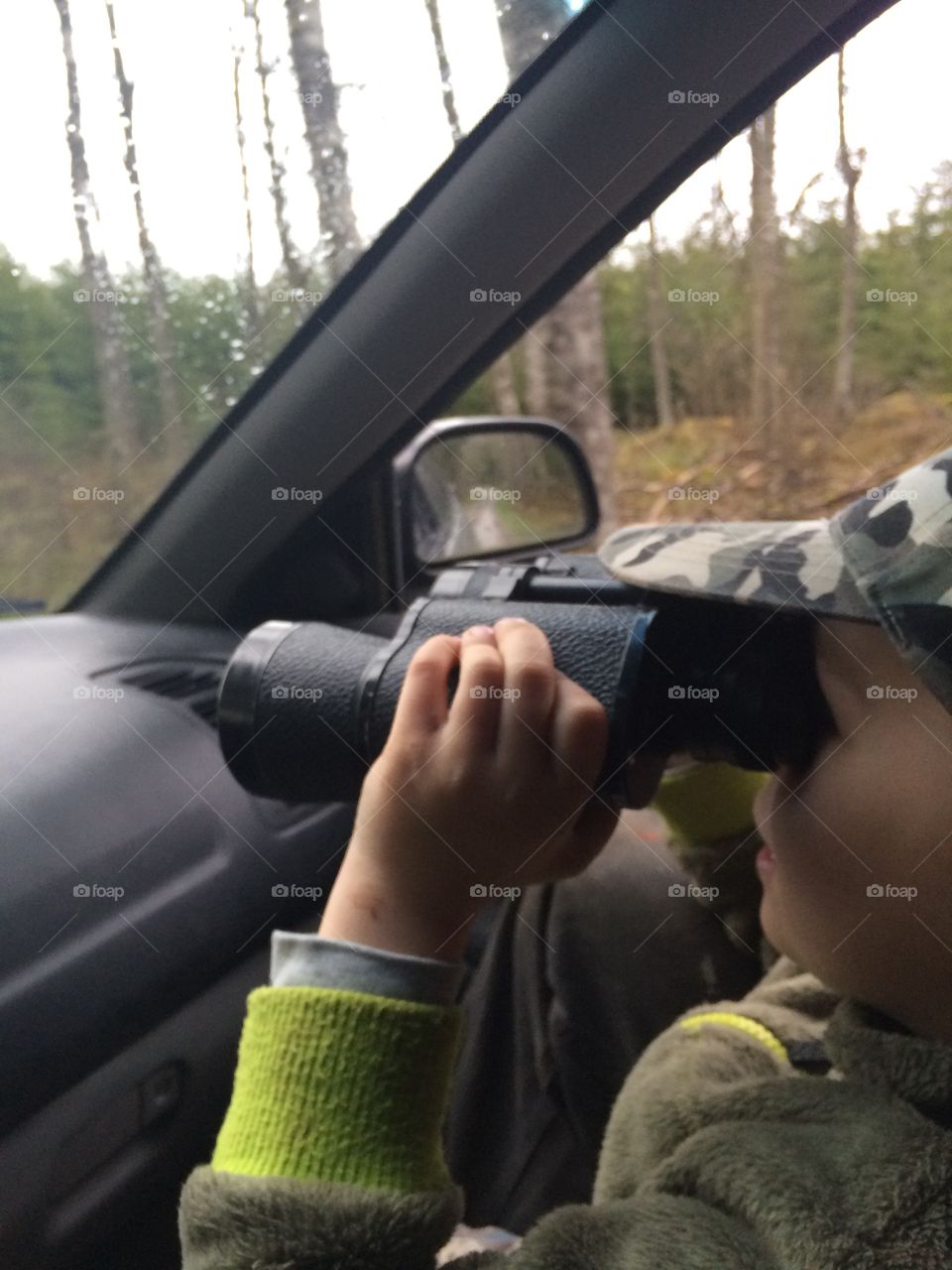 Boy in a car with a telescope