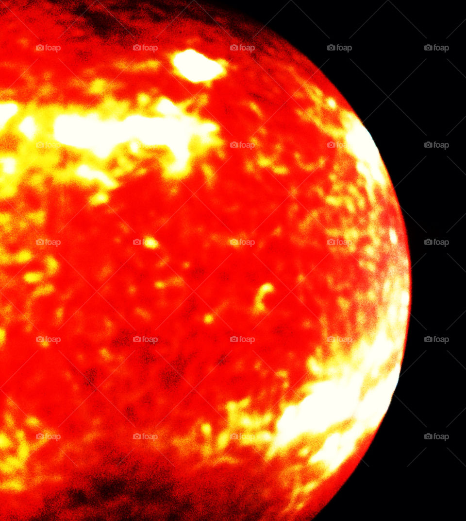 Satellite image of our sun in bright orange and yellow infrared