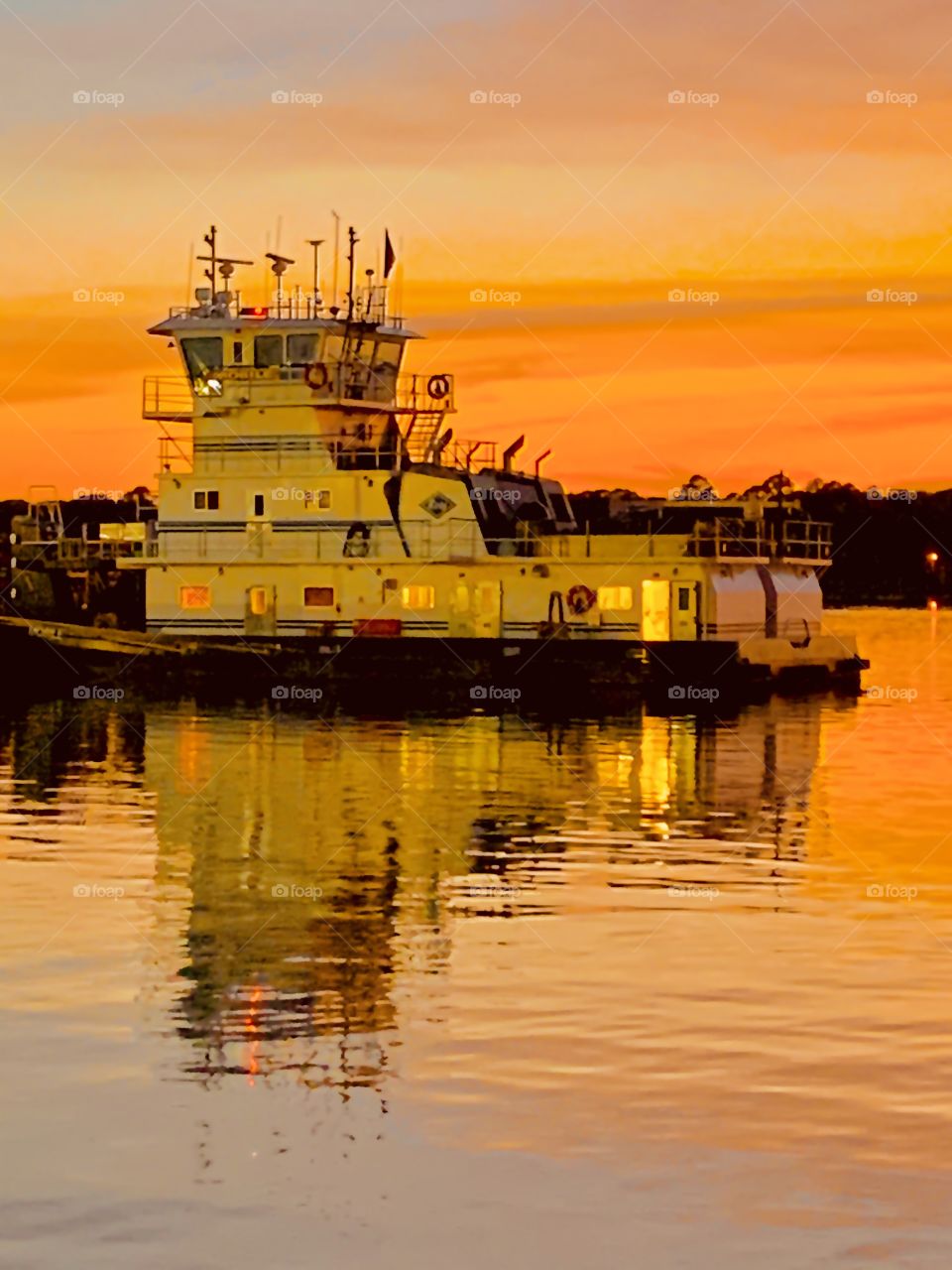 Tugboat docked on the bayou during sunset after pushing an oil tanker towards the port 