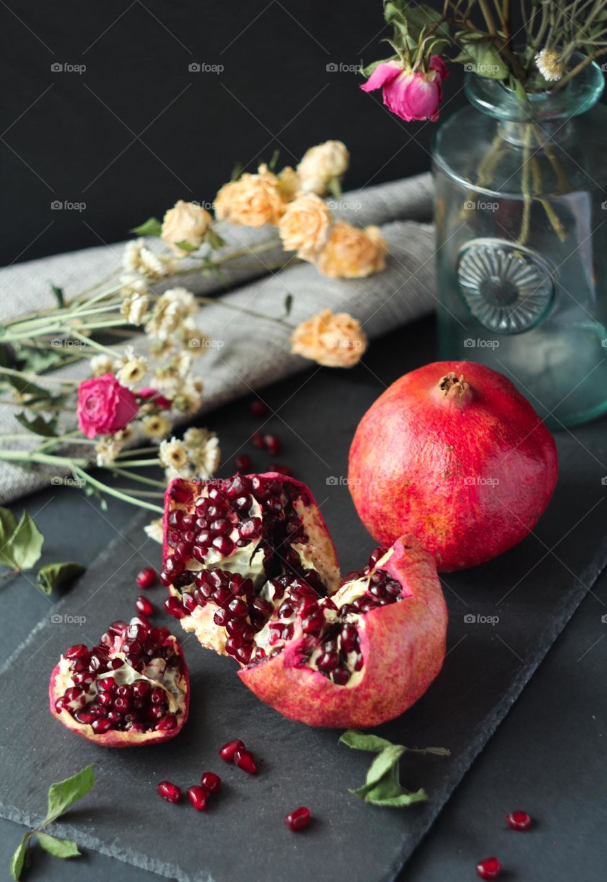 A fresh red pomegranate on a blackboard