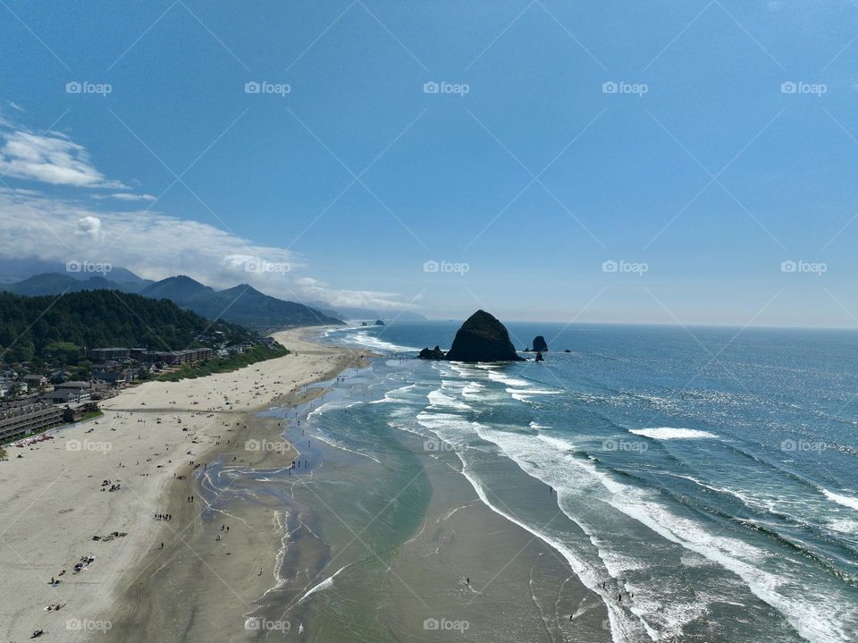 Haystack Rock standing tall amidst the serene beauty of Cannon Beach, where tide pools meet the endless horizon