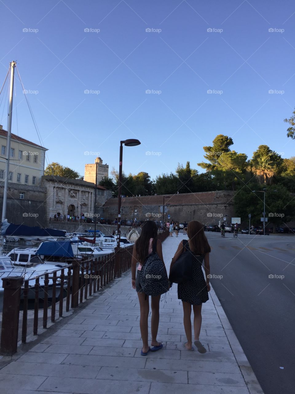 Girls walking by a harbour 