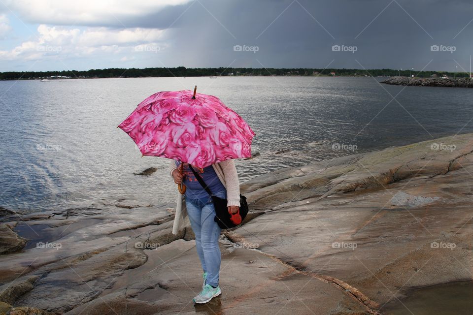 Woman with pink umbrella at the beach