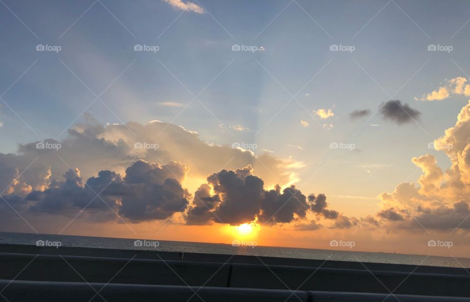 Sunset beach ocean clouds rays view 