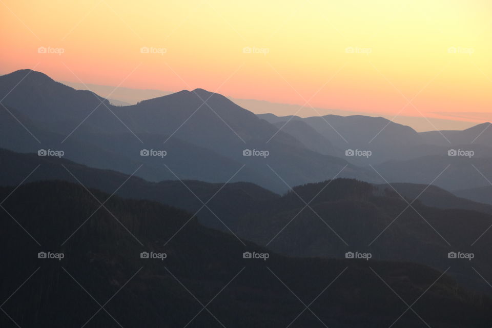 Sun setting behind the  mountain range dividing it all with a different shade